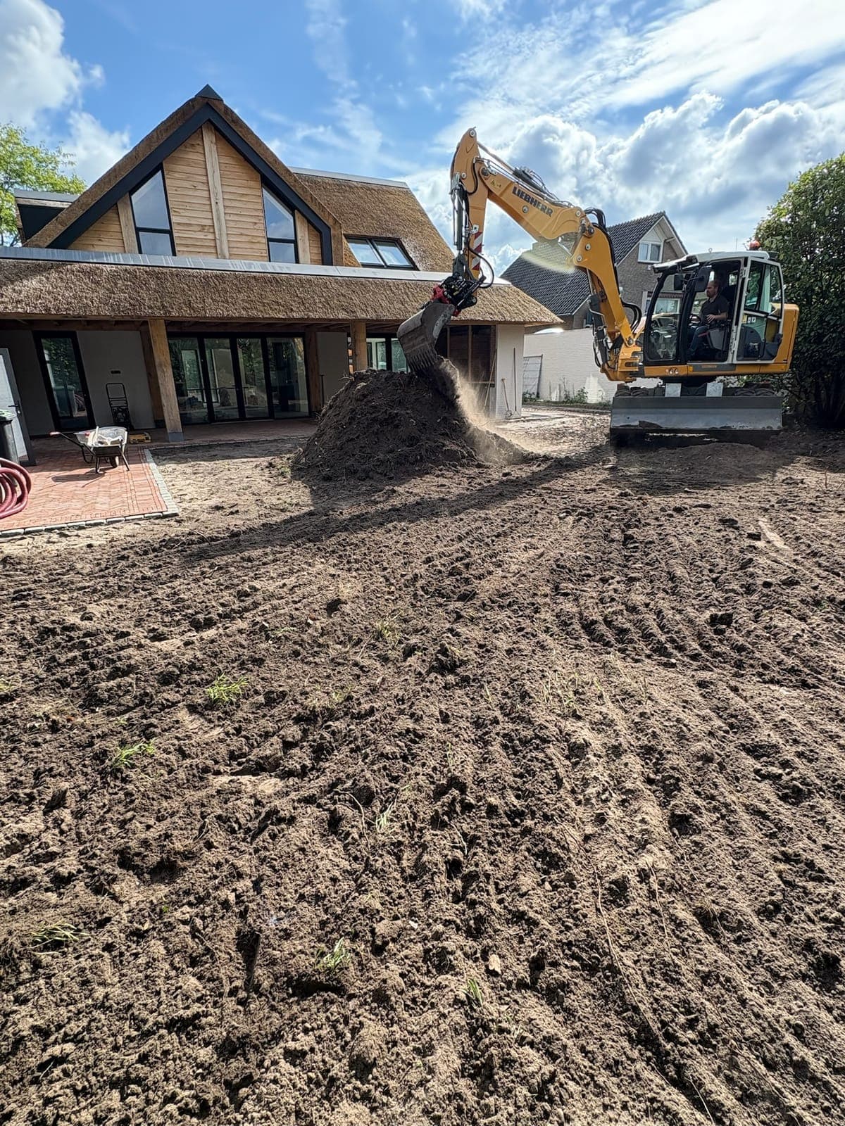Graafmachine verzet grond rondom de woning