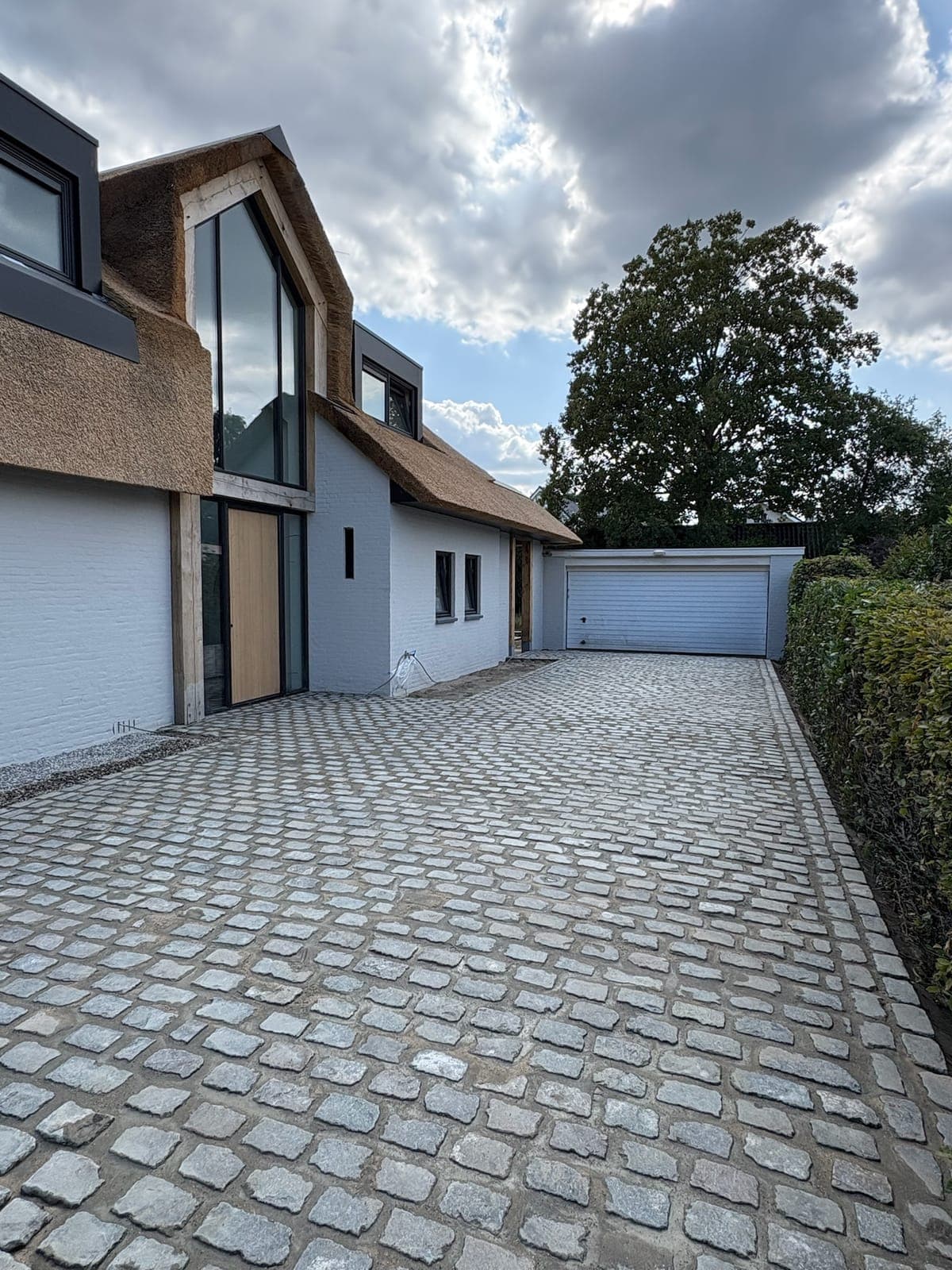 Ruime oprit in kinderkoppen bij een woning met rieten kap