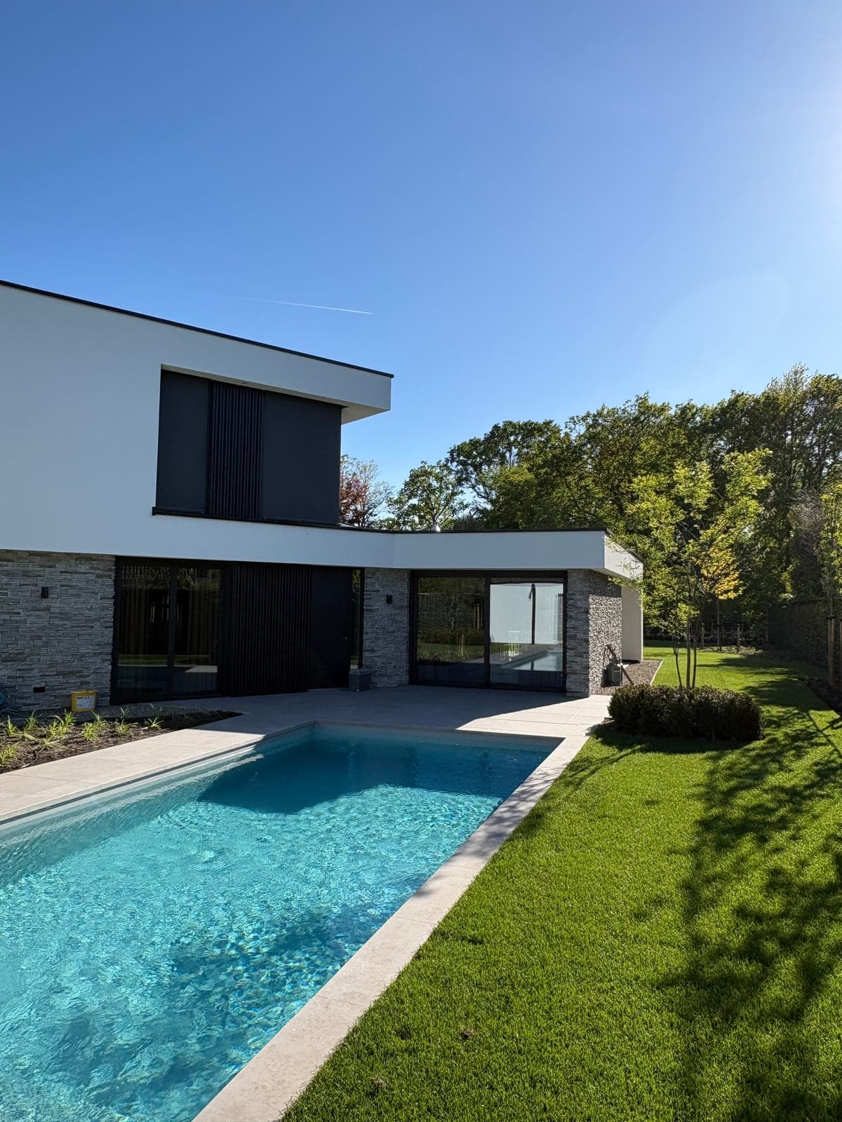 Moderne villatuin met zwembad en strak gazon in Moergestel